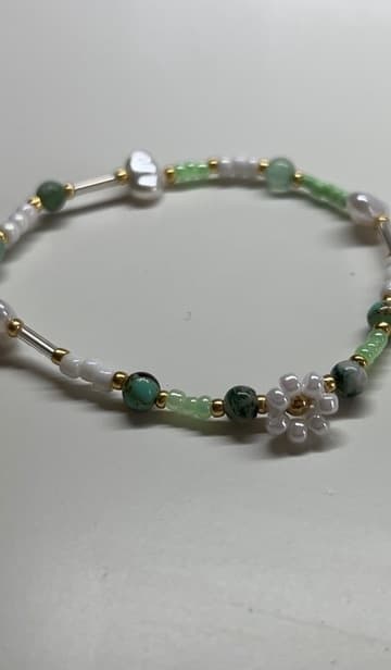 Armband in Grün und Weiß mit Perlenblümchen, Glasstäbchen und goldenen Zwischenperlen
