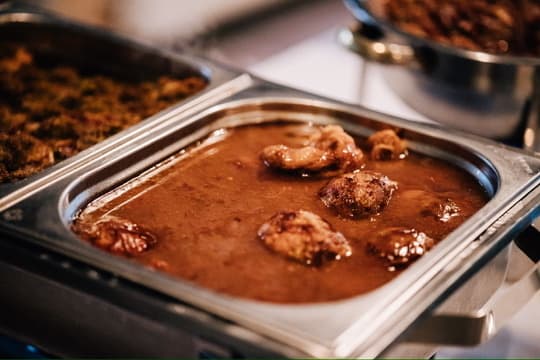 Fleischbällchen in brauner Soße im Buffetbehälter